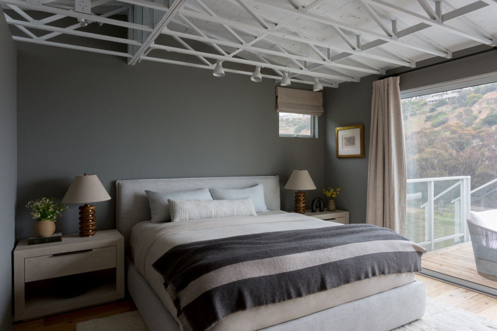 Exemple d'une petite chambre parentale bord de mer avec un mur gris et un sol en bois brun.