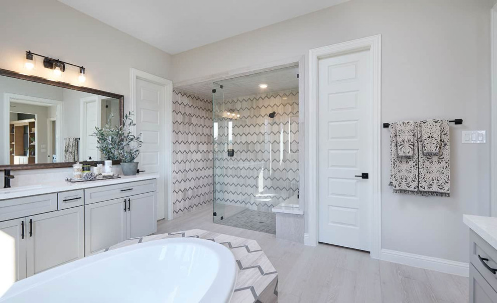 Photo of a contemporary ensuite bathroom in Houston with recessed-panel cabinets, grey cabinets, a built-in bath, an alcove shower, grey walls, porcelain flooring, a submerged sink, grey floors, an open shower, white worktops, an enclosed toilet, double sinks and a built in vanity unit.