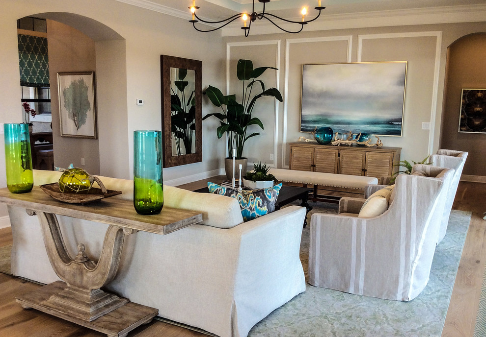 Photo of a mid-sized transitional open concept family room in Miami with beige walls, light hardwood floors, no fireplace, a freestanding tv and beige floor.