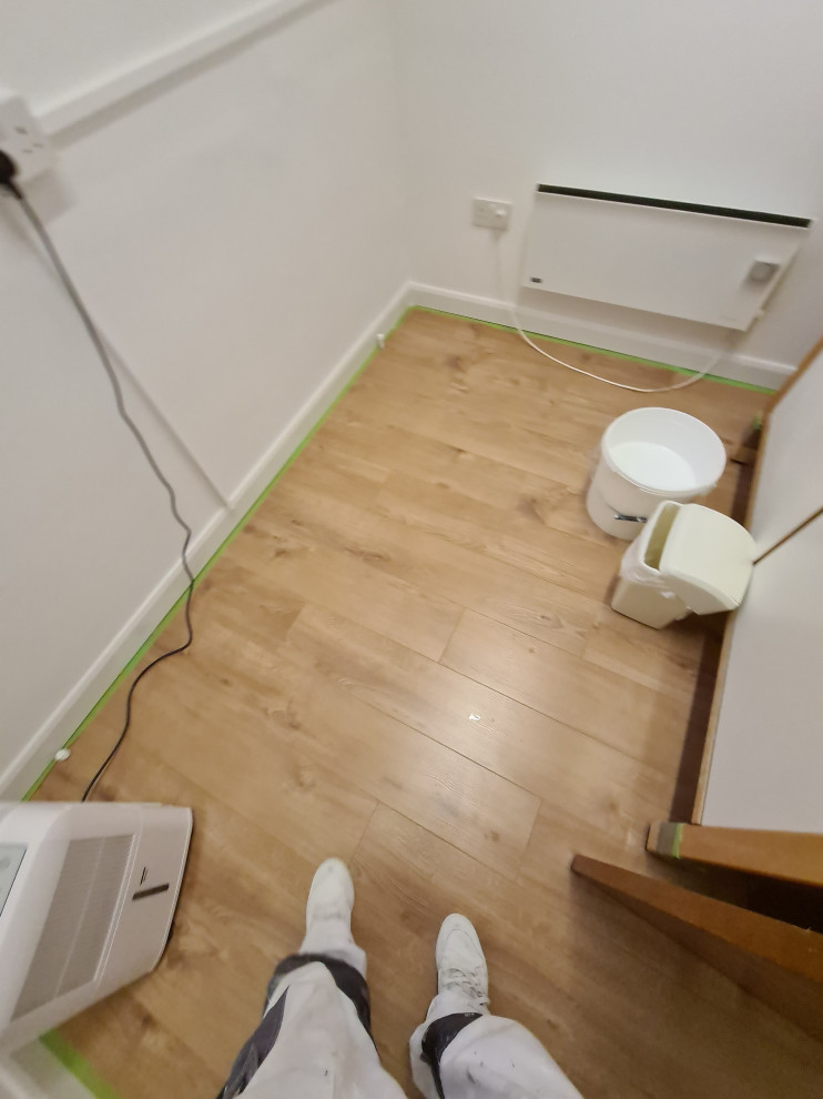 Photo of a large modern craft room in London with white walls, dark hardwood flooring and brown floors.