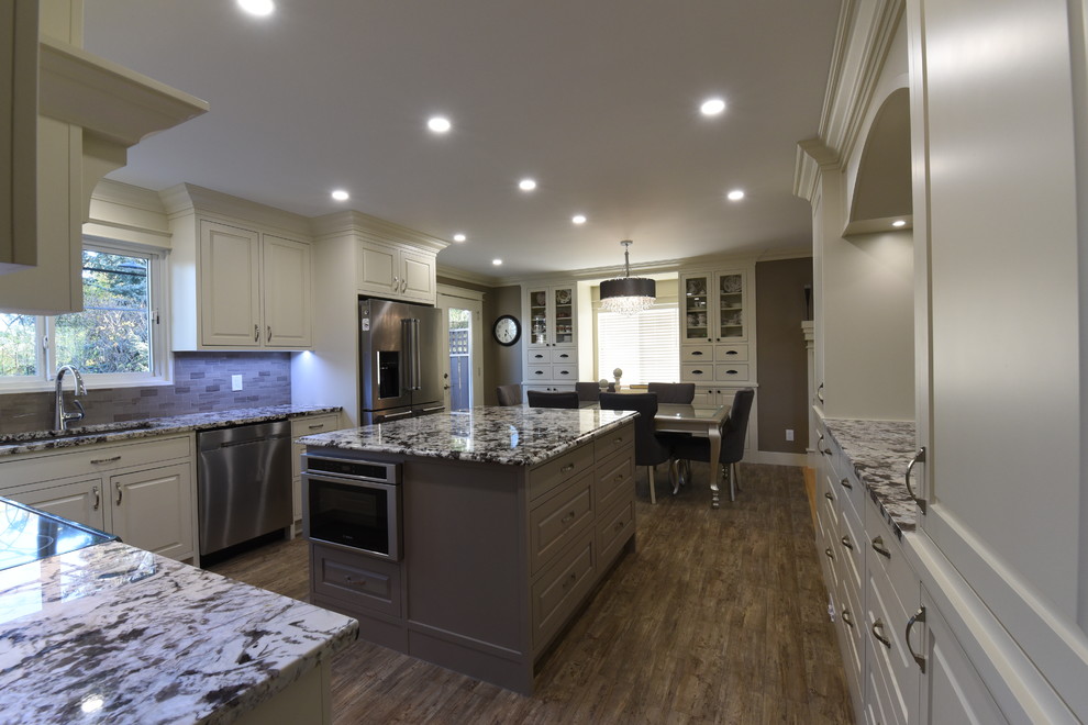 Example of a mid-sized transitional u-shaped vinyl floor and gray floor eat-in kitchen design in Calgary with an undermount sink, beaded inset cabinets, white cabinets, granite countertops, gray backsplash, ceramic backsplash, stainless steel appliances, two islands and gray countertops