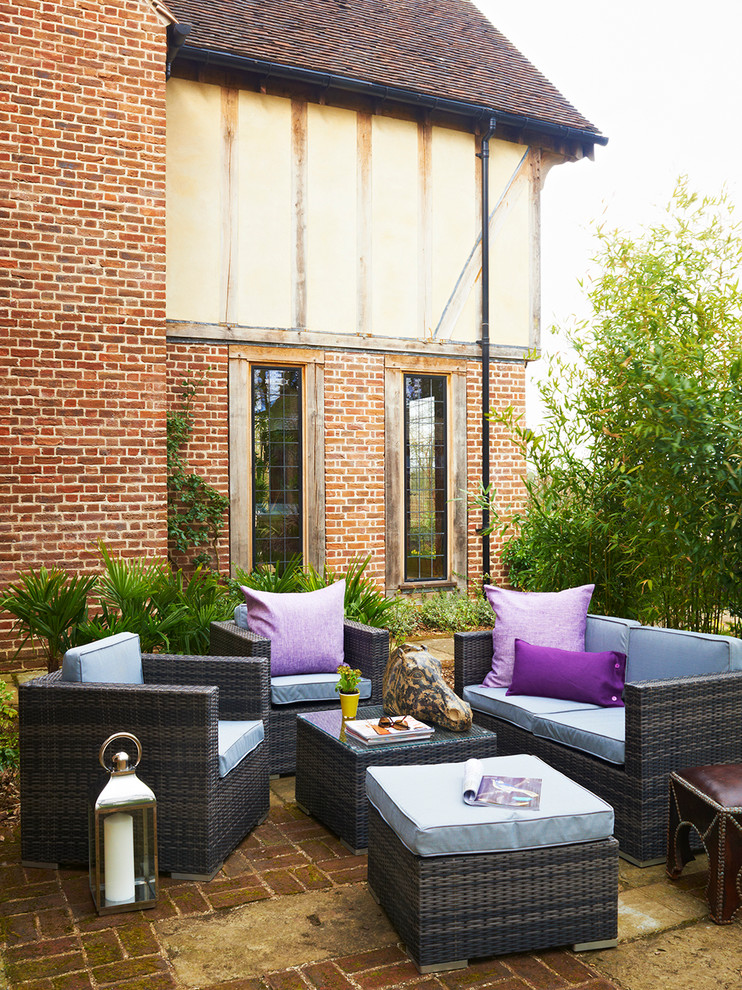 Inspiration for a traditional side yard patio in Hertfordshire with brick pavers.