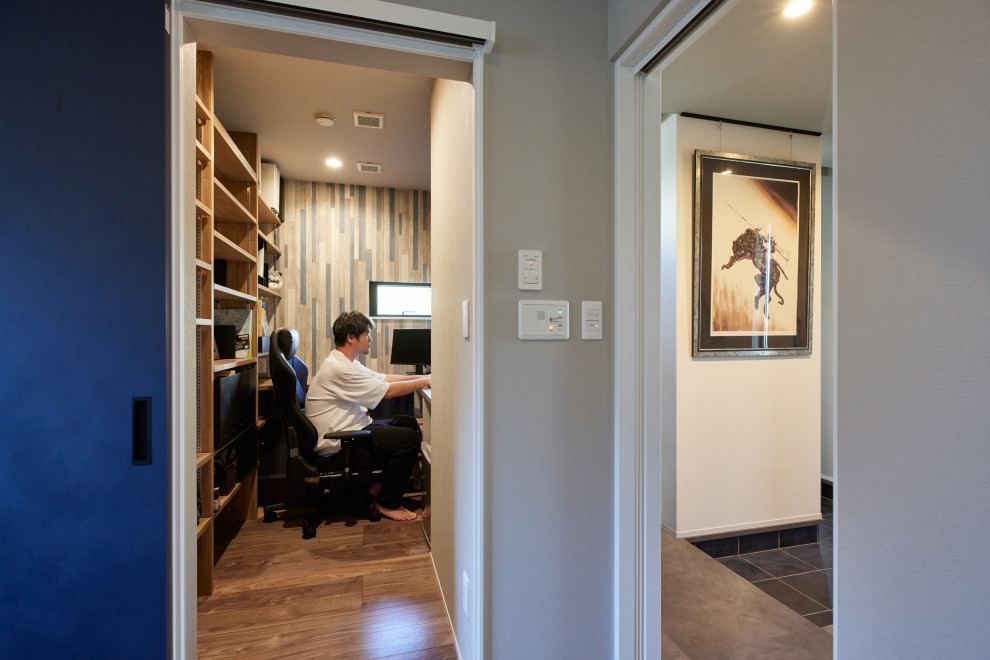 Idee per un ufficio moderno con pareti multicolore, pavimento in compensato, scrivania incassata, pavimento grigio, soffitto in carta da parati e carta da parati