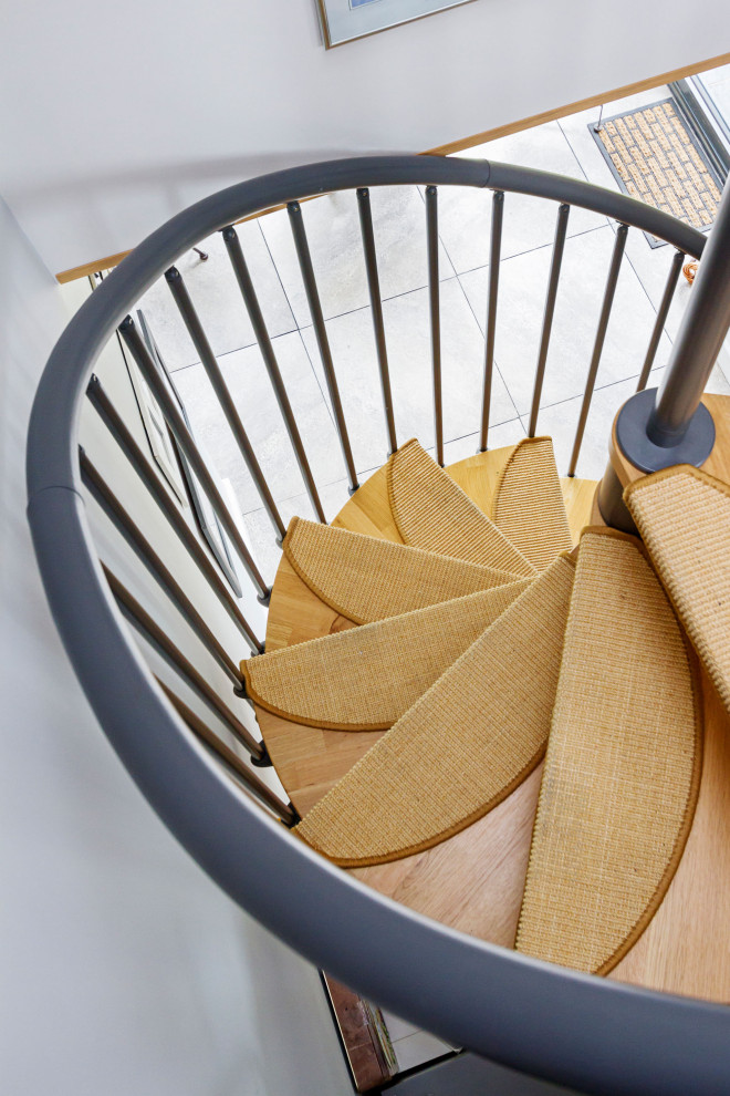 Inspiration for a small modern wood spiral metal railing staircase in West Midlands with metal risers.