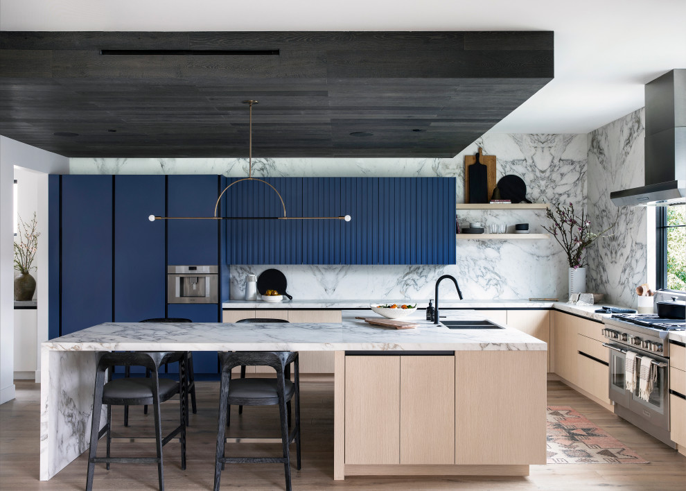 Aménagement d'une cuisine contemporaine avec des portes de placard bleues et îlot.