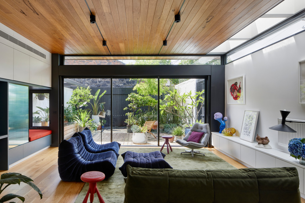 Mittelgroßes, Offenes Wohnzimmer mit weißer Wandfarbe, hellem Holzboden, beigem Boden und Holzdielendecke in Melbourne