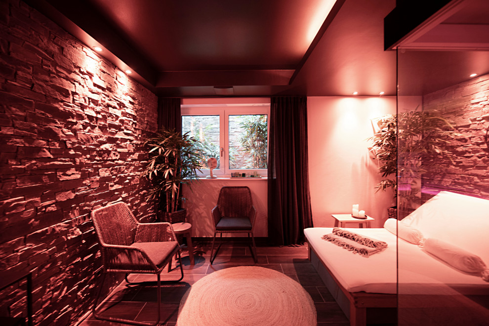 Mittelgroßes Modernes Untergeschoss mit beiger Wandfarbe, braunem Boden und Wandpaneelen in München