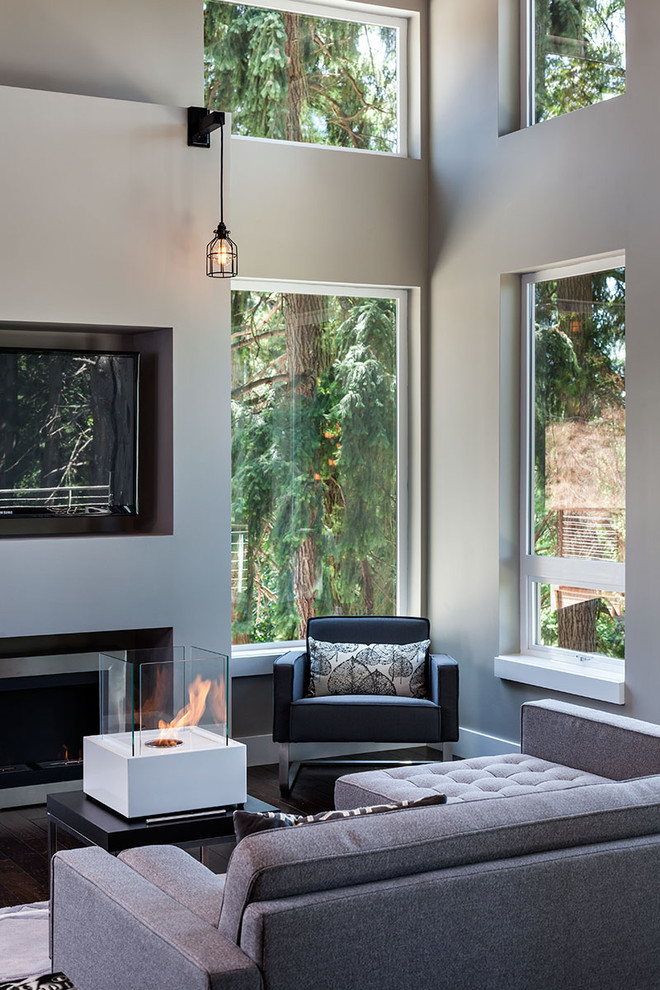 Inspiration for a large contemporary open concept family room in Portland with grey walls, dark hardwood floors, a ribbon fireplace and a wall-mounted tv.