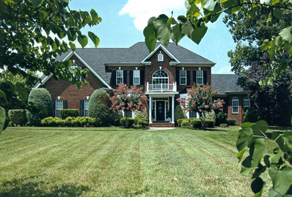 Inspiration for an expansive traditional three-storey brick red exterior in Charlotte with a hip roof.