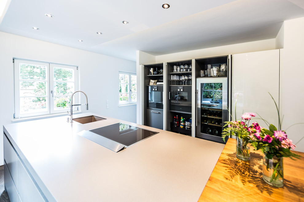 Expansive modern eat-in kitchen in Other with flat-panel cabinets, grey cabinets, concrete benchtops, with island, an undermount sink and stainless steel appliances.
