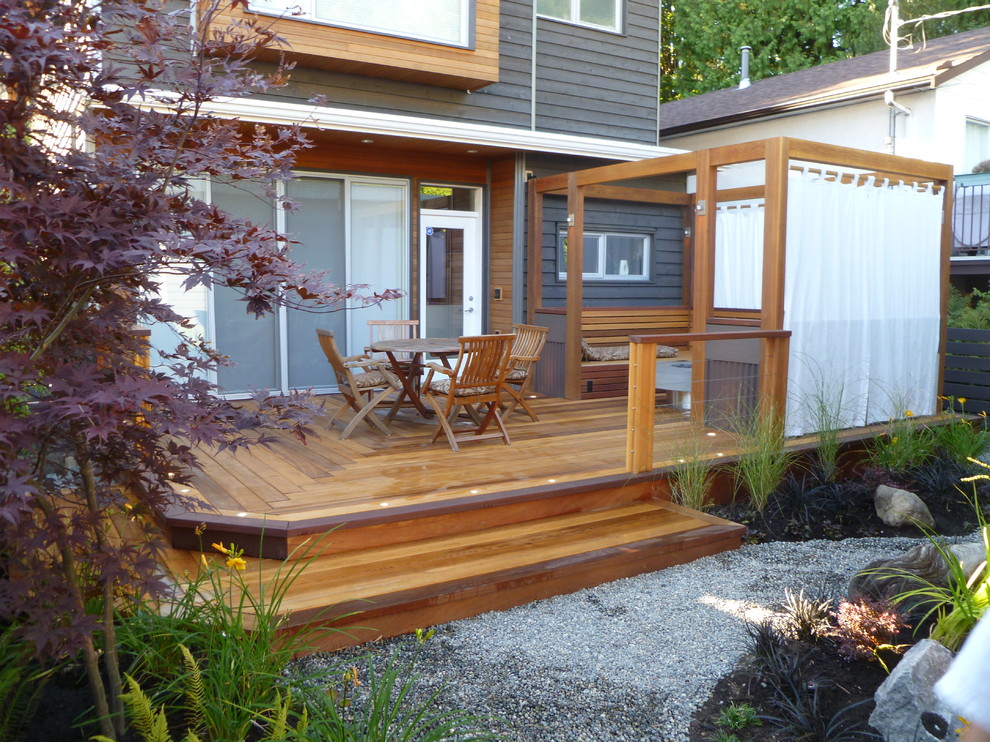 Mid-sized transitional backyard deck photo in Vancouver with a fire pit and a pergola