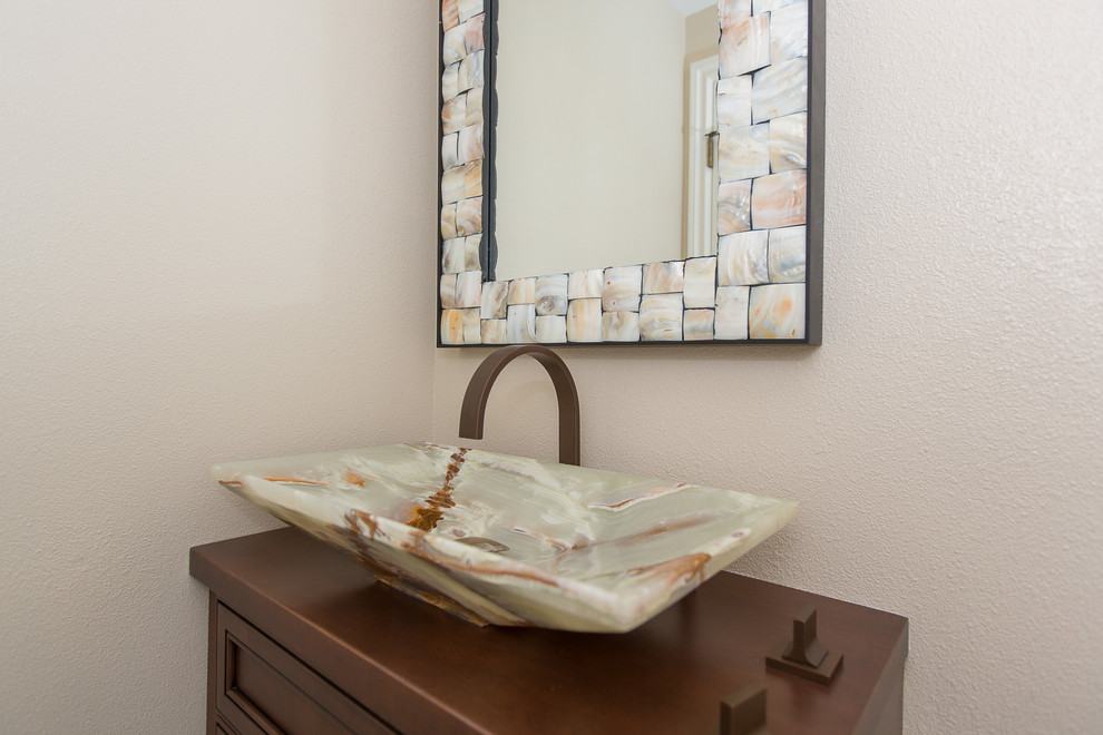 This is an example of a small transitional powder room in Orange County with a vessel sink, wood benchtops, a two-piece toilet and beige walls.