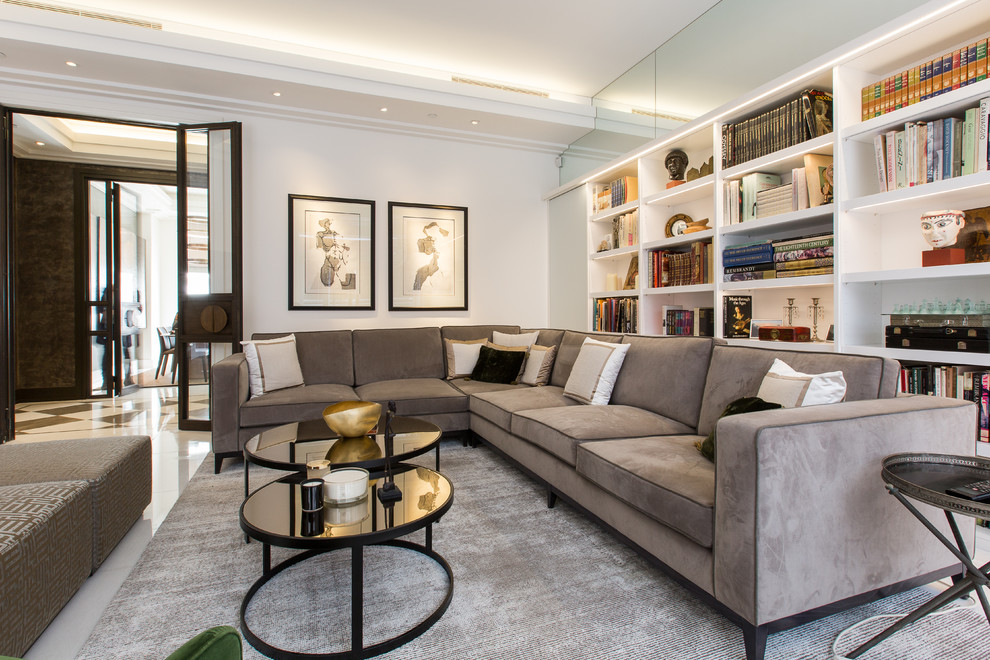 This is an example of a contemporary living room in London with a library, white walls, no fireplace and no tv.