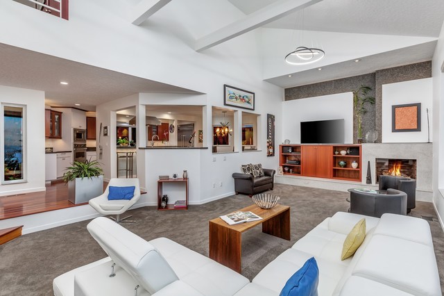 Living room - large modern open concept carpeted and gray floor living room idea in Portland with white walls, a standard fireplace, a stone fireplace and a wall-mounted tv