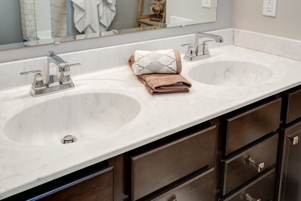 Inspiration for a mid-sized transitional master tub/shower combo remodel with dark wood cabinets, gray walls, an integrated sink and marble countertops