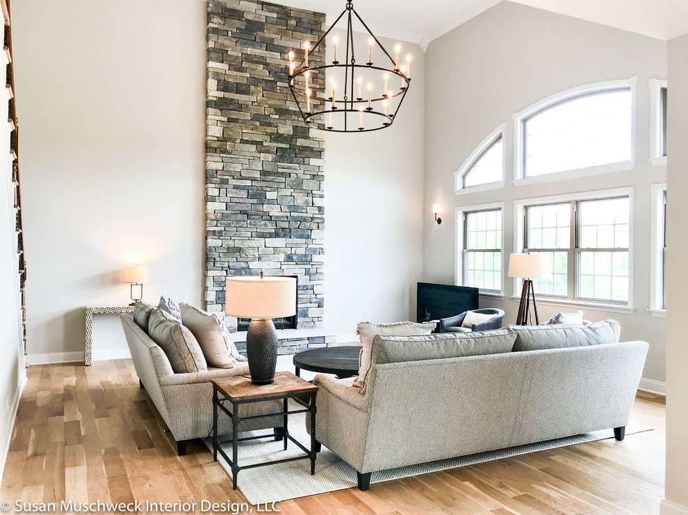 Example of a large transitional open concept light wood floor home design design with white walls, a standard fireplace and a stone fireplace
