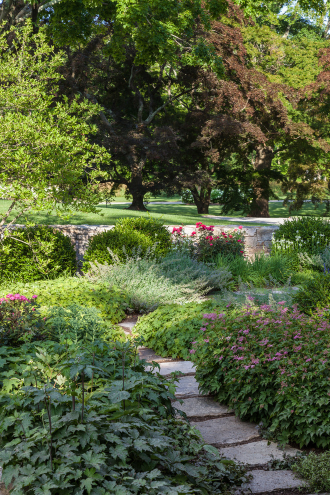 Country shaded garden in New York with a garden path and natural stone pavers.