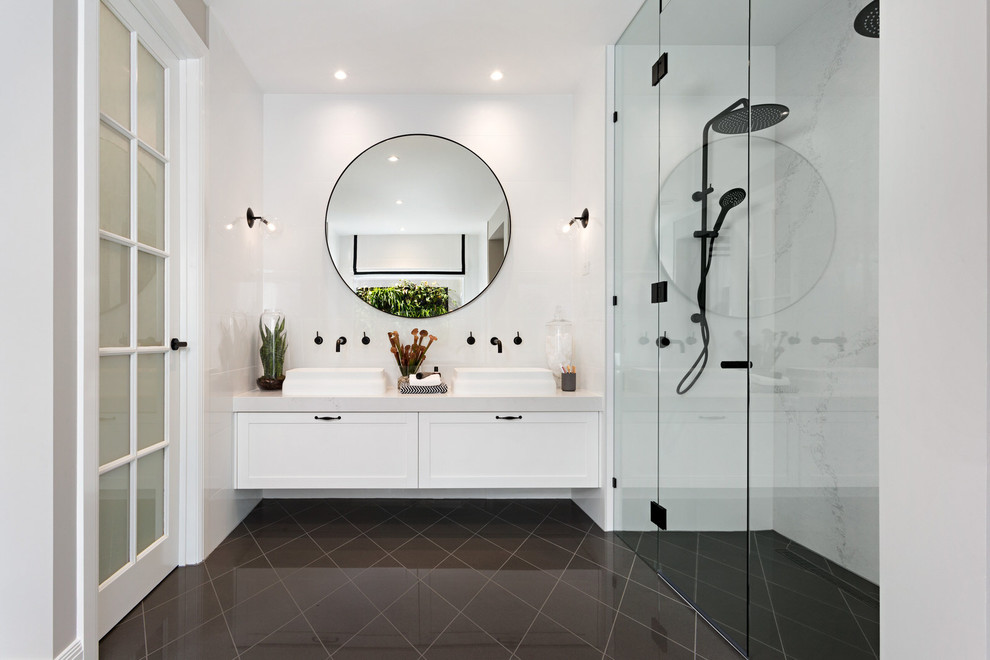 This is an example of a mid-sized transitional bathroom in Melbourne with recessed-panel cabinets, white cabinets, a vessel sink, a curbless shower, white walls and a hinged shower door.