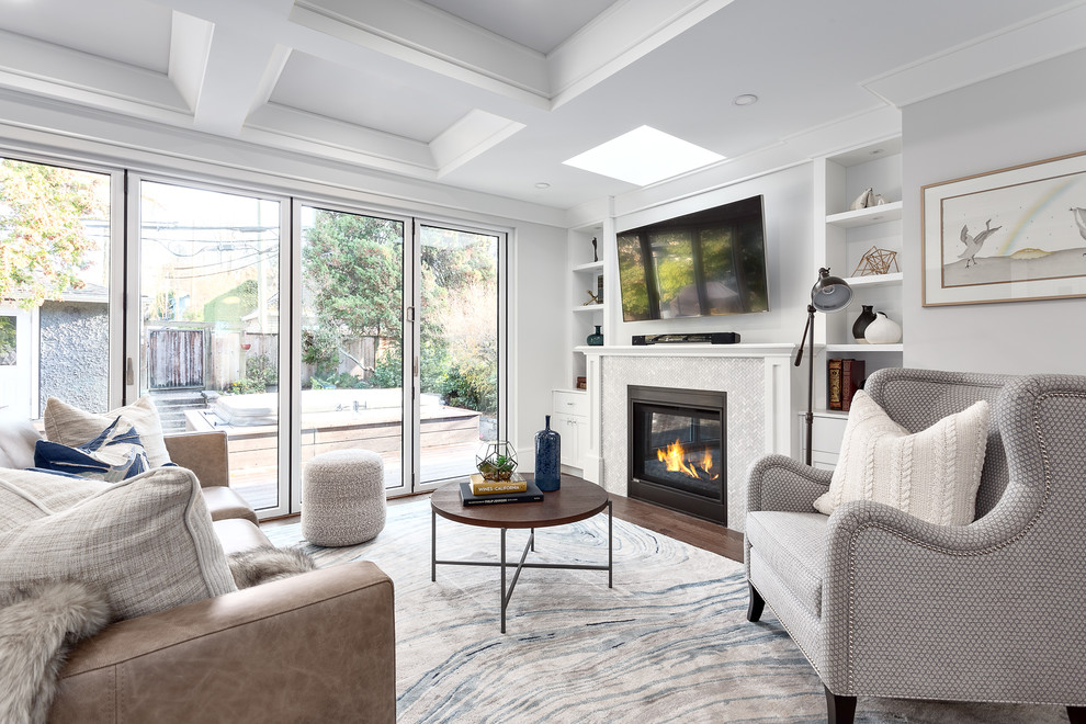 Mid-sized transitional open concept family room in Vancouver with grey walls, a standard fireplace, a tile fireplace surround, brown floor, dark hardwood floors and a wall-mounted tv.