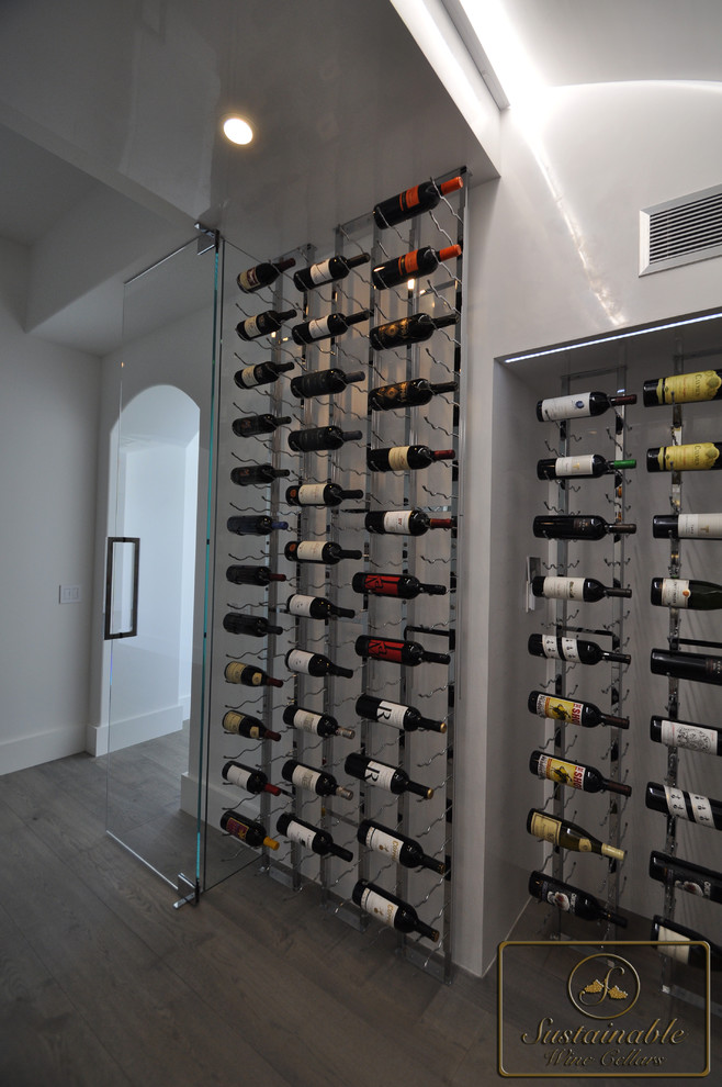 Design ideas for a mid-sized contemporary wine cellar in Orange County with medium hardwood floors and display racks.