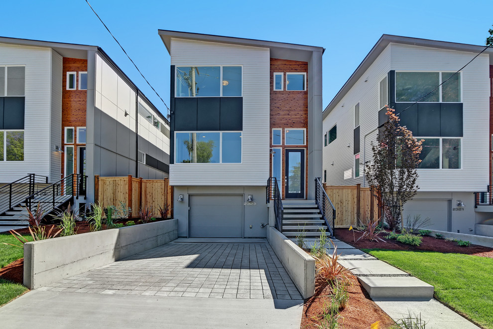 This is an example of a modern three-storey white exterior in Seattle with mixed siding.