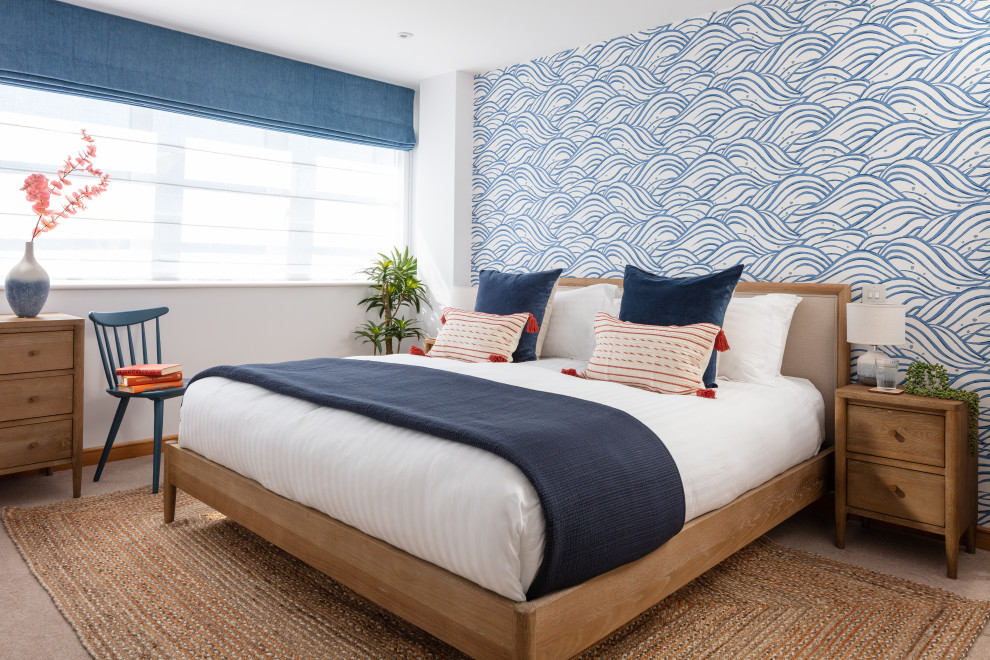 Diseño de dormitorio principal marinero de tamaño medio sin chimenea con paredes azules, moqueta, suelo beige y papel pintado