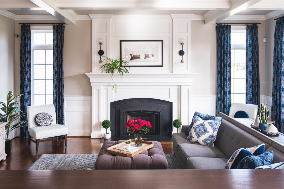 Mid-sized transitional living room in Philadelphia with beige walls, medium hardwood floors, a standard fireplace, a wood fireplace surround, a freestanding tv and coffered.