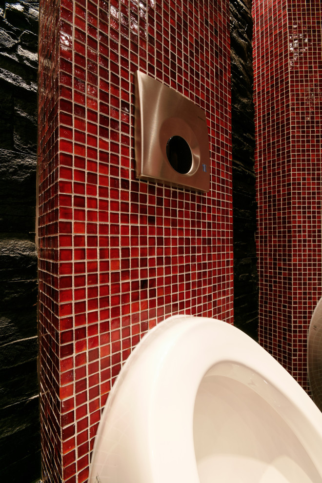 Photo of an expansive world-inspired cloakroom in Munich with a wall mounted toilet, red tiles, glass tiles, black walls, slate flooring, a console sink, glass worktops, black floors, feature lighting, a freestanding vanity unit and a drop ceiling.