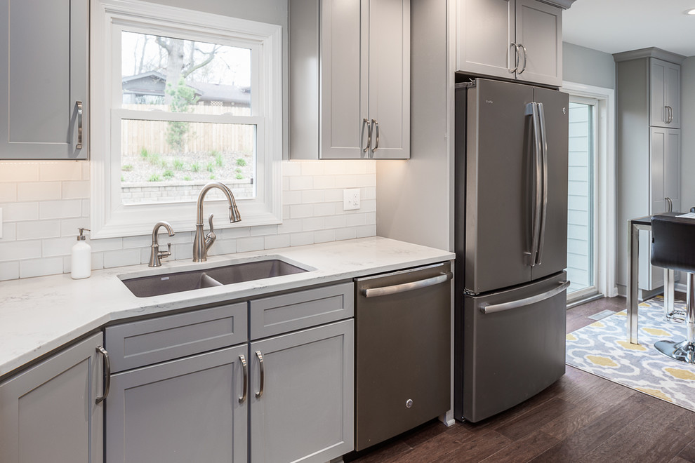 Inspiration for a mid-sized transitional u-shaped laminate floor and brown floor eat-in kitchen remodel with an undermount sink, recessed-panel cabinets, gray cabinets, quartzite countertops, white backsplash, subway tile backsplash, stainless steel appliances and no island