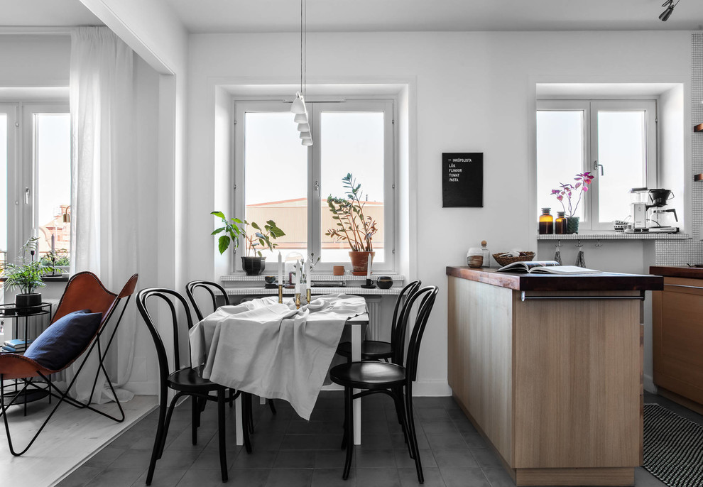 Mid-sized scandinavian open plan dining in Stockholm with white walls and grey floor.