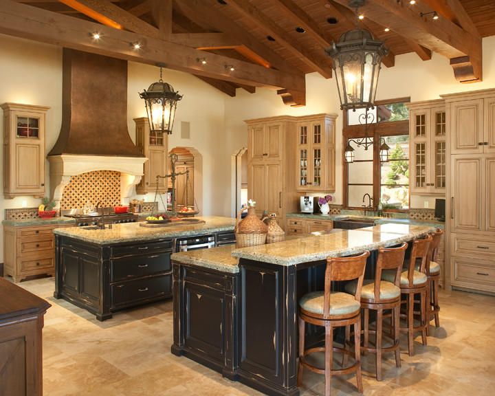 Design ideas for a mid-sized mediterranean kitchen in San Diego with multiple islands, a farmhouse sink, beaded inset cabinets, light wood cabinets, granite benchtops, multi-coloured splashback, cement tile splashback, stainless steel appliances, travertine floors and brown floor.