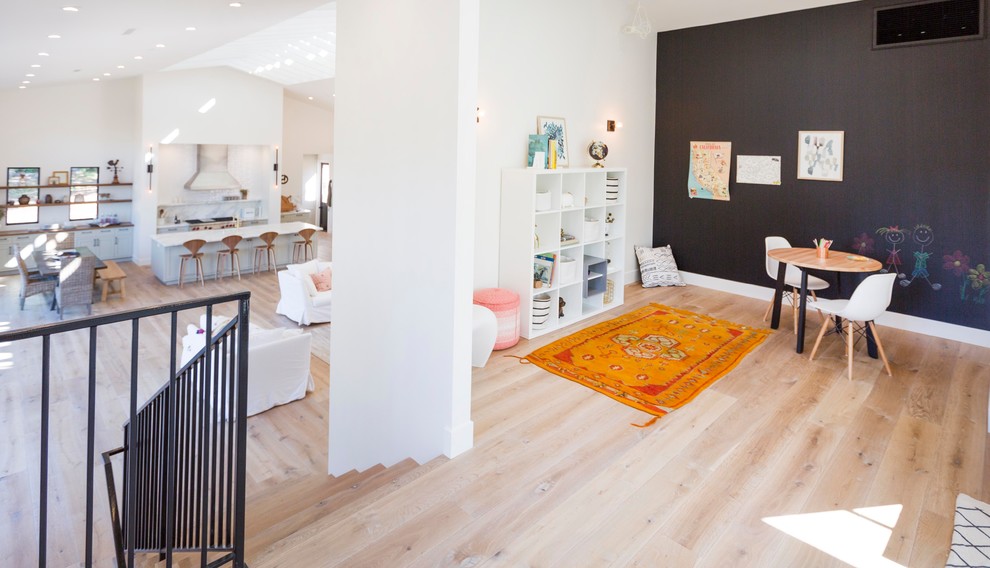 This is an example of a mid-sized modern kids' playroom in San Diego with light hardwood floors.