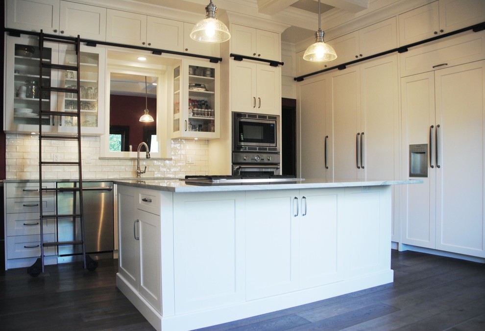 Inspiration for a large transitional light wood floor and brown floor eat-in kitchen remodel in Vancouver with an undermount sink, shaker cabinets, white cabinets, quartzite countertops, white backsplash, ceramic backsplash, stainless steel appliances and an island