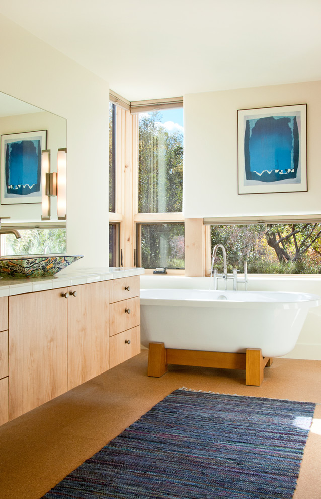 Inspiration for a bathroom in Denver with a vessel sink, light wood cabinets and a freestanding tub.