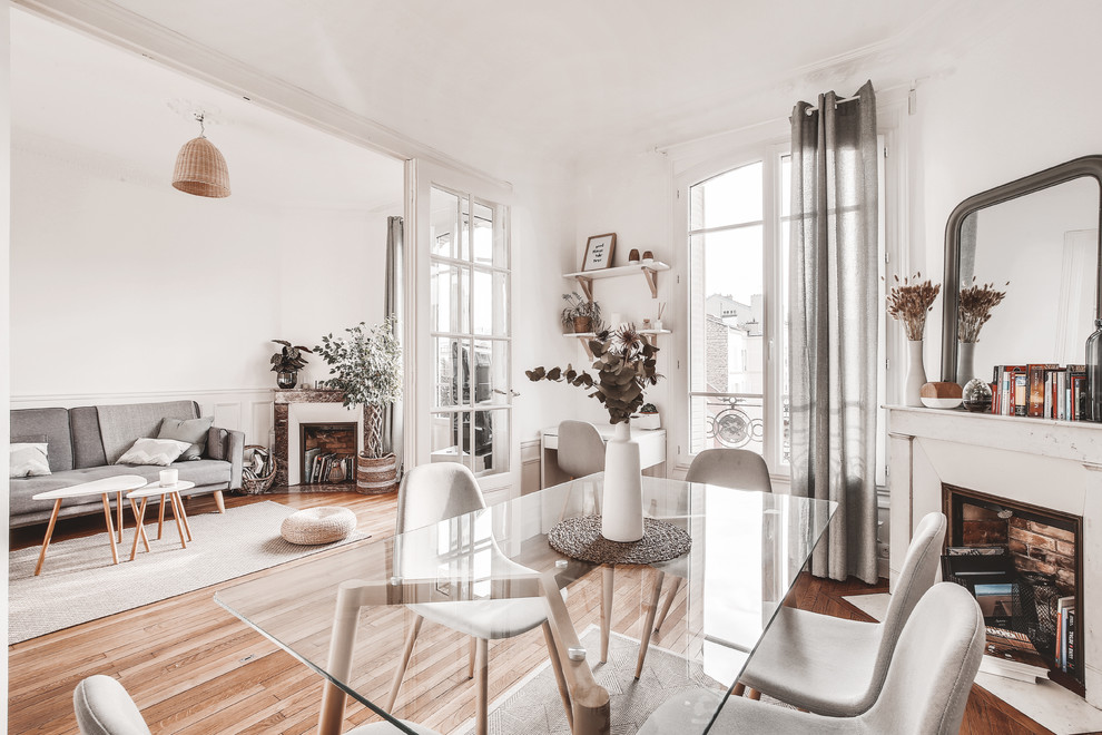 Inspiration for a small scandinavian separate dining room in Paris with white walls, light hardwood floors, no fireplace and brown floor.