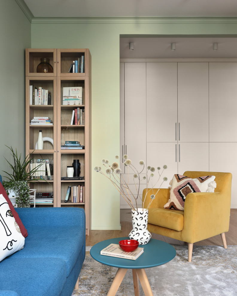 Идея дизайна: гостиная комната среднего размера в скандинавском стиле с разноцветными стенами, паркетным полом среднего тона, коричневым полом и синим диваном без телевизора