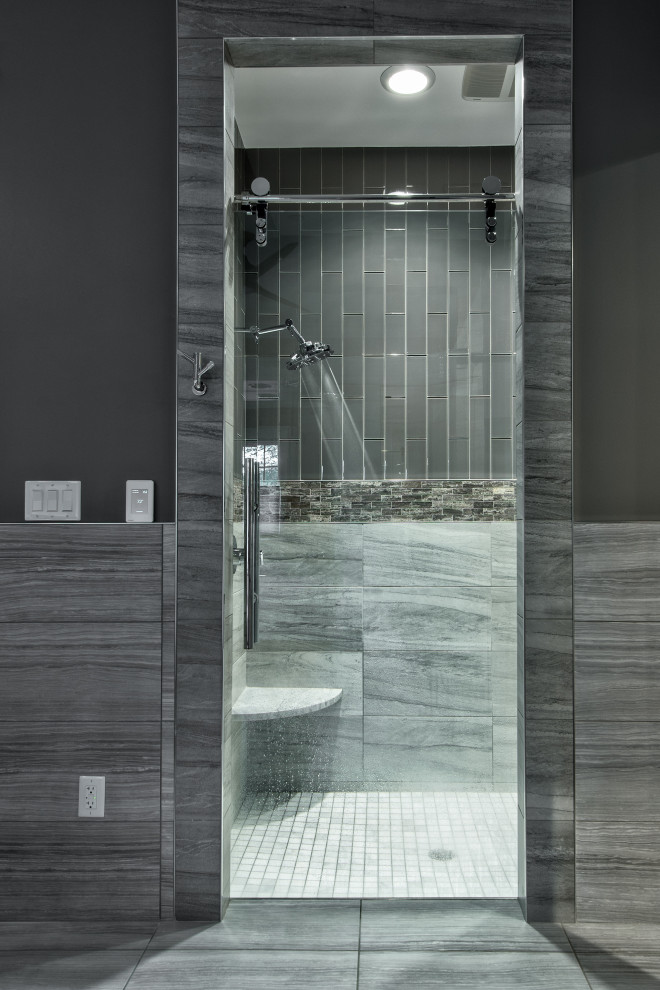 This is an example of a large contemporary master bathroom in Other with raised-panel cabinets, white cabinets, an undermount tub, a curbless shower, a one-piece toilet, gray tile, glass tile, grey walls, porcelain floors, an undermount sink, quartzite benchtops, grey floor, a sliding shower screen, grey benchtops, a double vanity and a floating vanity.