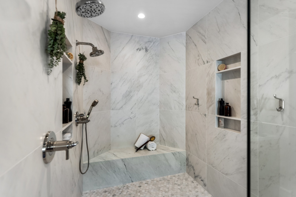 This is an example of an expansive transitional master bathroom in Los Angeles with shaker cabinets, medium wood cabinets, a freestanding tub, an alcove shower, a wall-mount toilet, white tile, porcelain tile, white walls, marble floors, an undermount sink, white floor, a hinged shower door, white benchtops, a shower seat, a single vanity and a built-in vanity.
