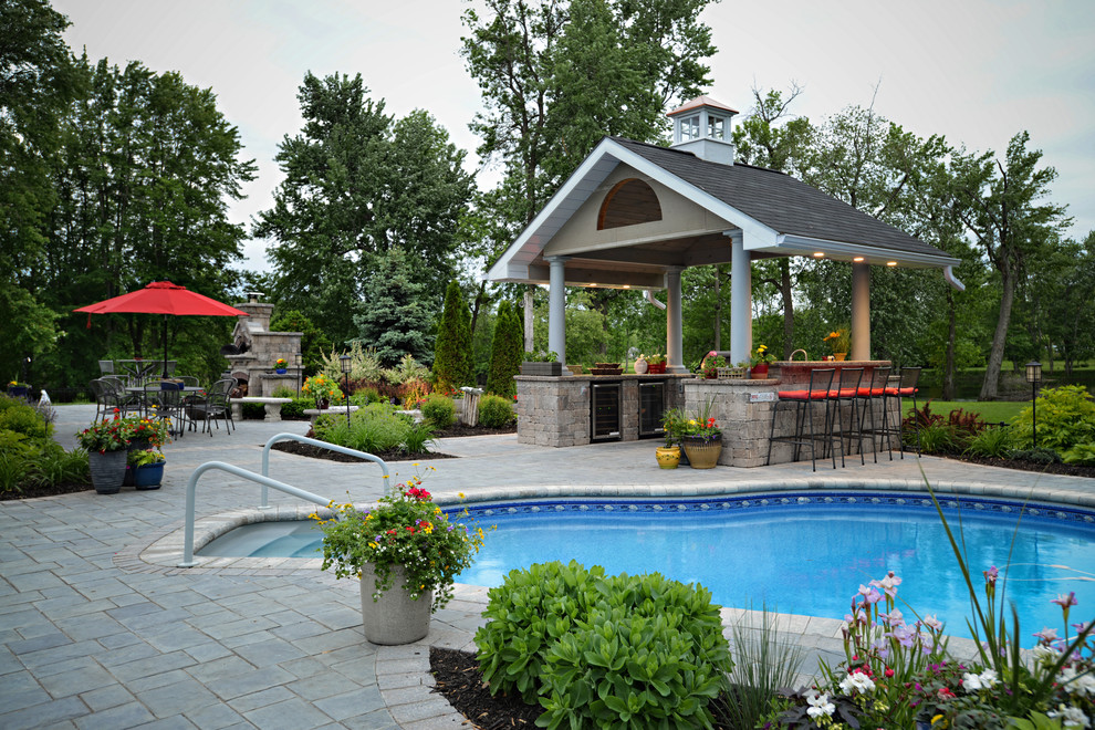 Traditional backyard pool in Toronto with concrete pavers.