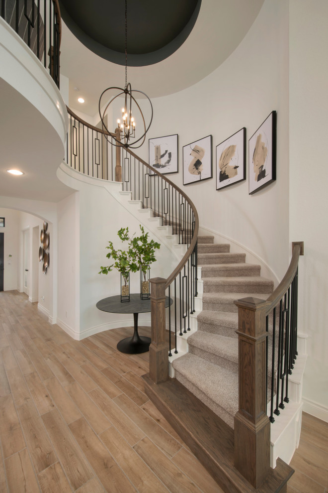 Свежая идея для дизайна: изогнутая лестница с ступенями с ковровым покрытием и перилами из смешанных материалов - отличное фото интерьера