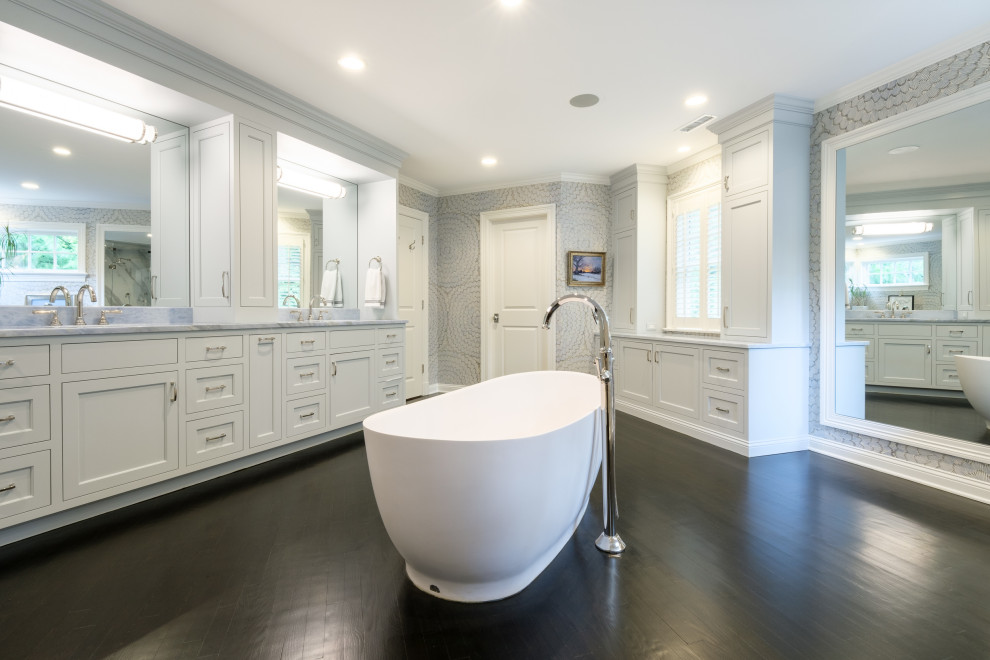 Huge transitional master dark wood floor, double-sink and wallpaper bathroom photo in New York with recessed-panel cabinets, gray cabinets, multicolored walls, an undermount sink, marble countertops, a hinged shower door, blue countertops and a built-in vanity