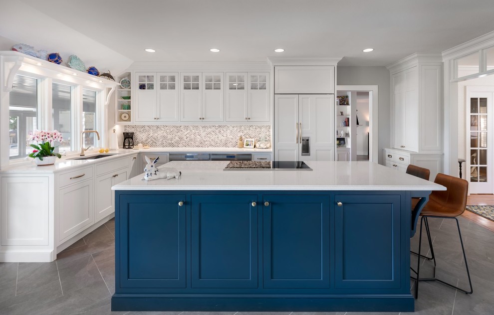 This is an example of a mid-sized traditional galley kitchen in Tampa with an undermount sink, beaded inset cabinets, white cabinets, quartz benchtops, blue splashback, mosaic tile splashback, stainless steel appliances, porcelain floors, with island, grey floor and white benchtop.