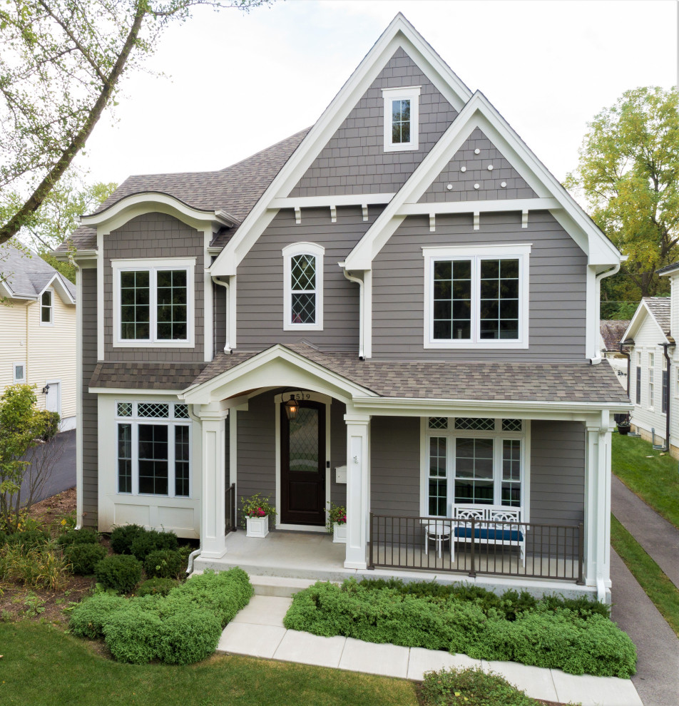 This is an example of a large traditional two-storey grey house exterior in Chicago with concrete fiberboard siding, a gable roof and a shingle roof.