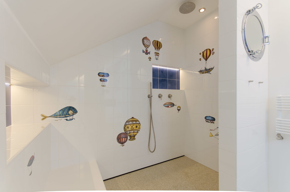 Large contemporary kids bathroom in Munich with an open shower, white tile, ceramic tile, an open shower, flat-panel cabinets, white cabinets, a drop-in tub, an undermount sink, limestone benchtops, a wall-mount toilet, white walls, ceramic floors and beige floor.