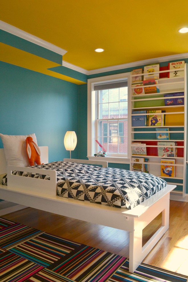 Mid-sized contemporary gender-neutral kids' bedroom in Boston with blue walls and light hardwood floors for kids 4-10 years old.