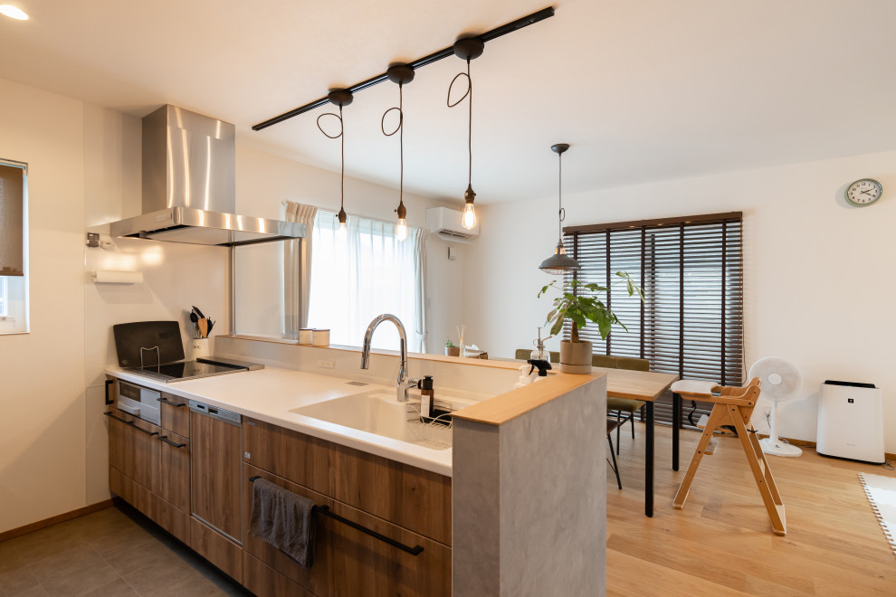 Aménagement d'une cuisine ouverte linéaire industrielle avec une crédence marron, un sol en bois brun, une péninsule, un sol marron, un plan de travail blanc et un plafond en papier peint.