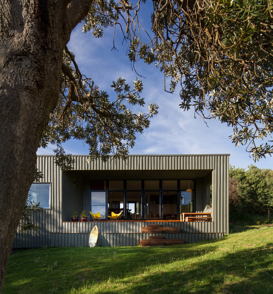 Contemporary one-storey green exterior in Melbourne with a flat roof and wood siding.