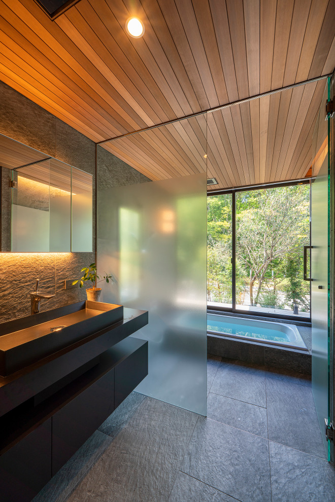 Свежая идея для дизайна: ванная комната в стиле модернизм с полновстраиваемой ванной, душевой комнатой, серыми стенами, серым полом и душем с распашными дверями - отличное фото интерьера