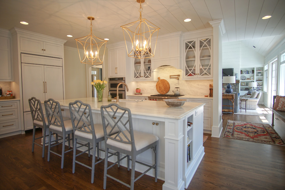 Inspiration for a mid-sized country l-shaped kitchen in Atlanta with an undermount sink, white cabinets, stainless steel appliances, with island, brown floor, white benchtop, shaker cabinets, white splashback, stone slab splashback and dark hardwood floors.