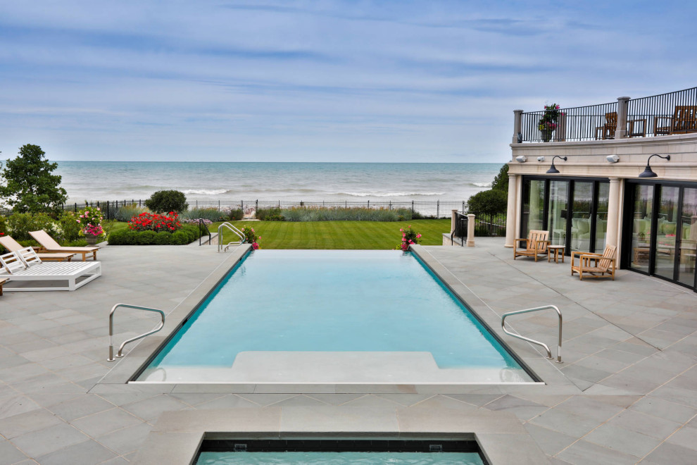 Foto di una piscina monocorsia tradizionale rettangolare di medie dimensioni e in cortile con paesaggistica bordo piscina e pavimentazioni in pietra naturale